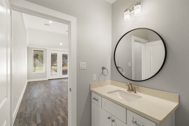 bathroom featuring vanity, wood-type flooring, and french doors