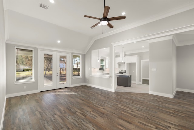 unfurnished living room featuring french doors, dark hardwood / wood-style flooring, ornamental molding, vaulted ceiling, and ceiling fan