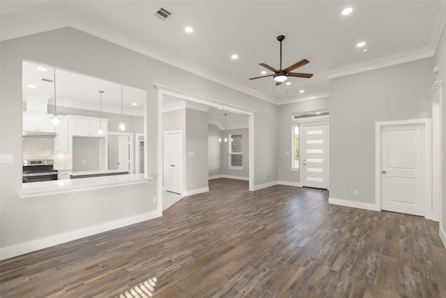 unfurnished living room featuring ceiling fan with notable chandelier, dark hardwood / wood-style floors, and ornamental molding