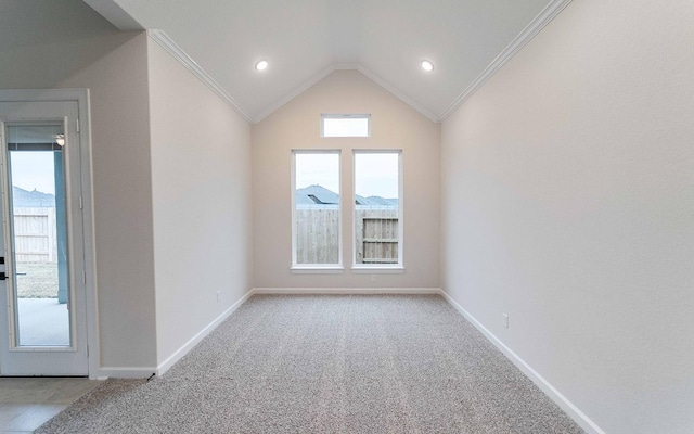 spare room with lofted ceiling, light carpet, crown molding, and baseboards