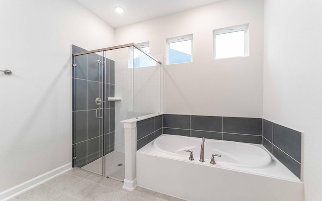 bathroom featuring tile patterned flooring, a shower stall, baseboards, and a bath