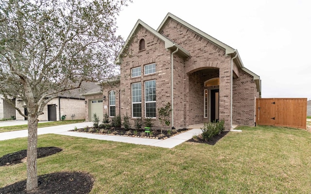 view of front of home featuring a garage, brick siding, concrete driveway, a gate, and a front yard