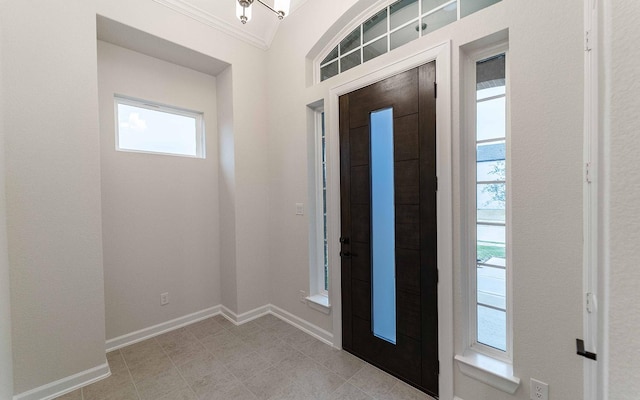 foyer with ornamental molding and baseboards