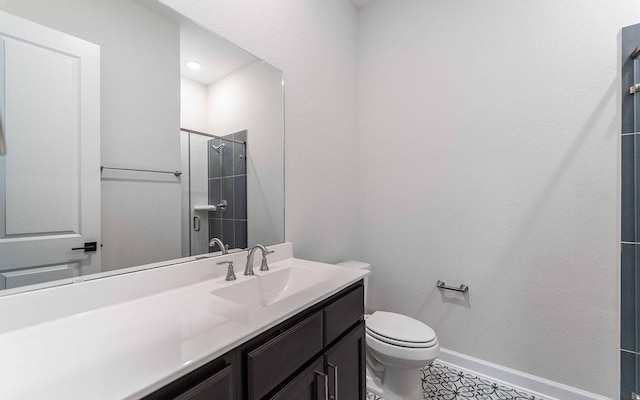 bathroom featuring a stall shower, toilet, vanity, and baseboards