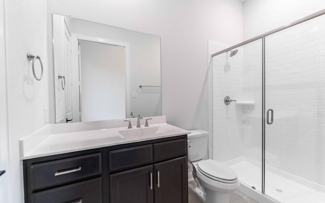 bathroom with a stall shower, vanity, and toilet