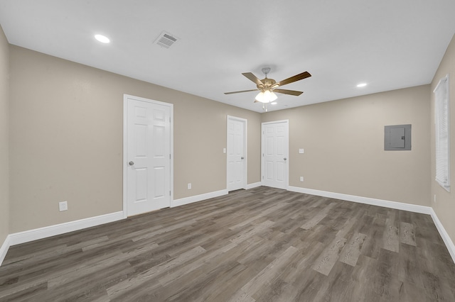 spare room with electric panel, ceiling fan, and dark hardwood / wood-style flooring