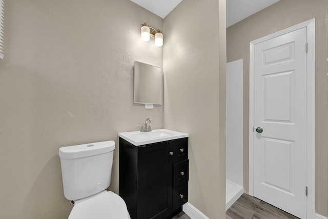 bathroom featuring wood-type flooring, vanity, and toilet