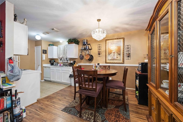 dining area featuring light hardwood / wood-style flooring and an inviting chandelier