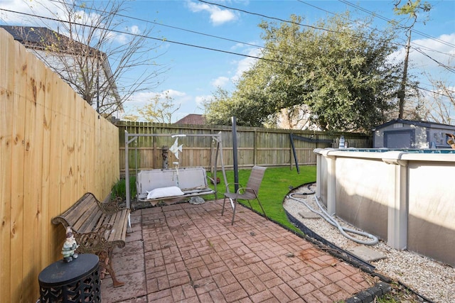 view of patio featuring a fenced in pool and a shed