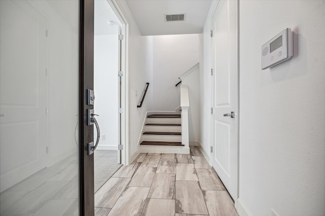 interior space with baseboards, stairs, and visible vents