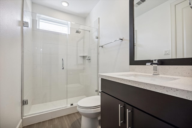 full bath featuring visible vents, toilet, wood finished floors, vanity, and a shower stall