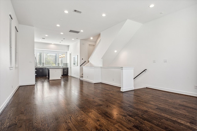 unfurnished living room featuring dark wood-type flooring, recessed lighting, visible vents, and baseboards