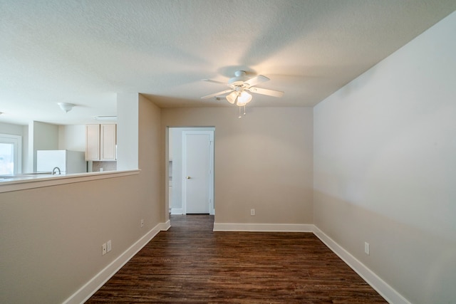 spare room featuring dark hardwood / wood-style floors, ceiling fan, and a textured ceiling