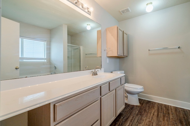 bathroom featuring vanity, hardwood / wood-style flooring, toilet, and a shower with door