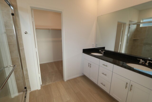 bathroom with vanity, hardwood / wood-style flooring, and a shower with shower door