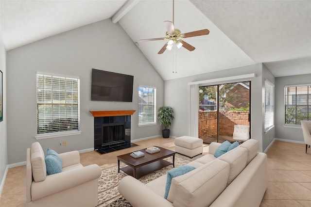 living room with ceiling fan, high vaulted ceiling, a tiled fireplace, beamed ceiling, and light tile patterned flooring