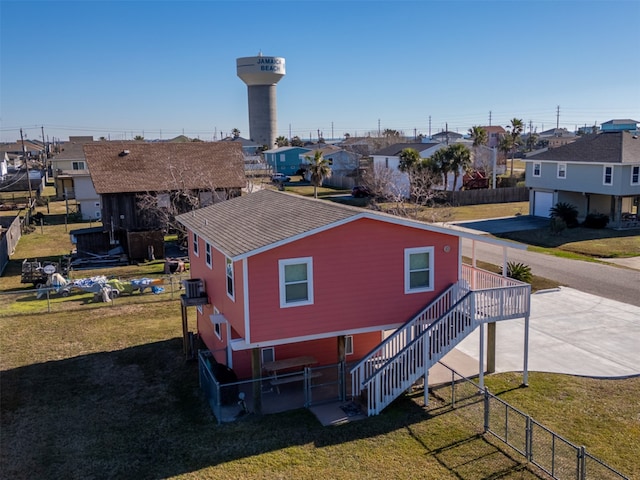 rear view of property with cooling unit, a residential view, a lawn, and fence