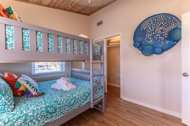 bedroom featuring wood finished floors, baseboards, visible vents, wood ceiling, and a closet