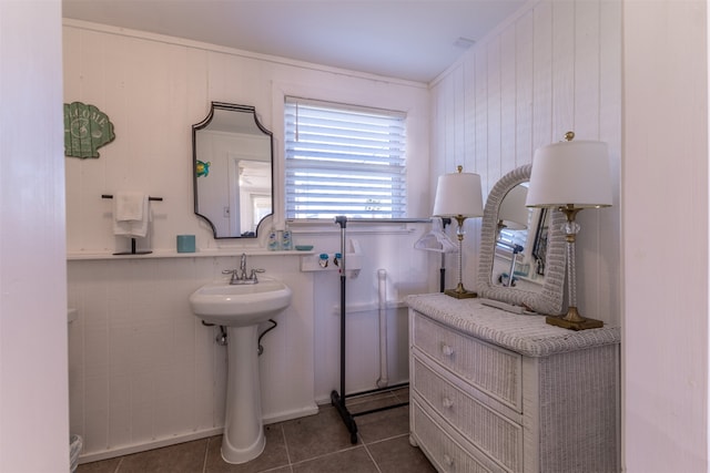 bathroom with tile patterned flooring and wooden walls