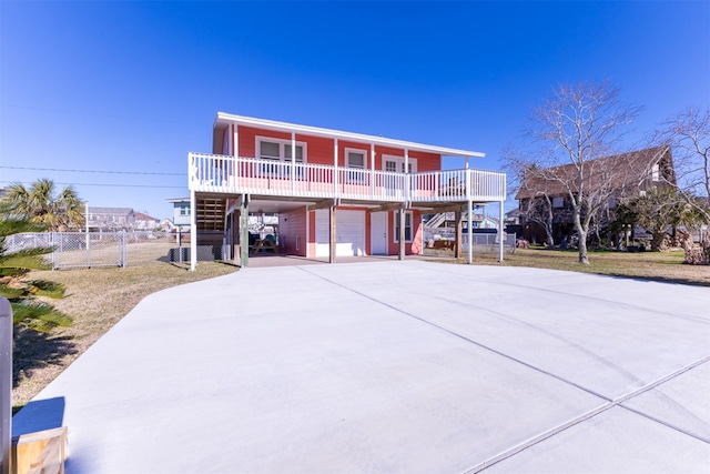 view of front of house featuring a carport, stairway, driveway, and fence