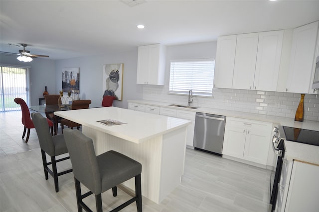 kitchen featuring a breakfast bar, white cabinetry, a center island, and appliances with stainless steel finishes