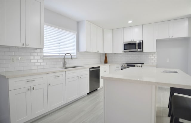 kitchen featuring light stone countertops, white cabinetry, sink, and appliances with stainless steel finishes