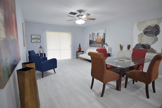 dining space with ceiling fan and light wood-type flooring