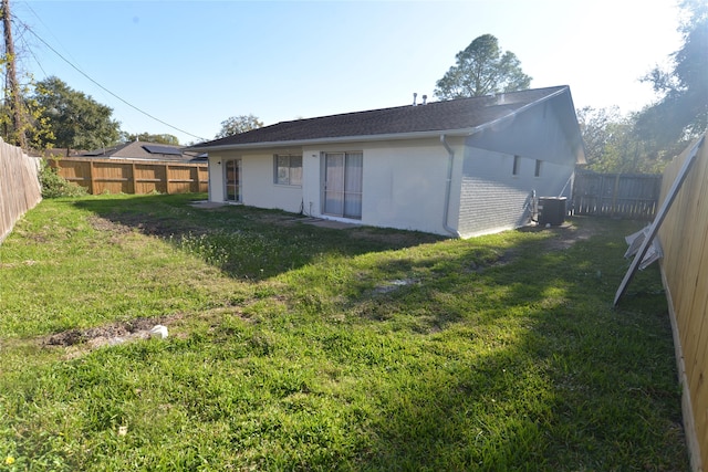 back of house featuring a lawn and central air condition unit