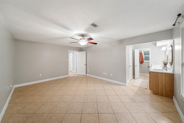 spare room featuring light tile patterned floors, ceiling fan, and sink