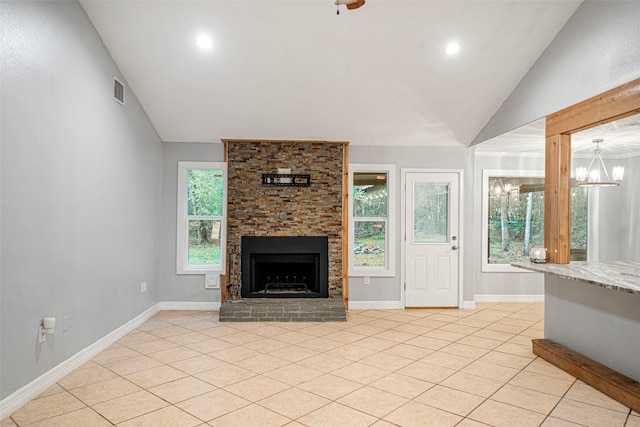 unfurnished living room featuring an inviting chandelier, light tile patterned flooring, a fireplace, and vaulted ceiling