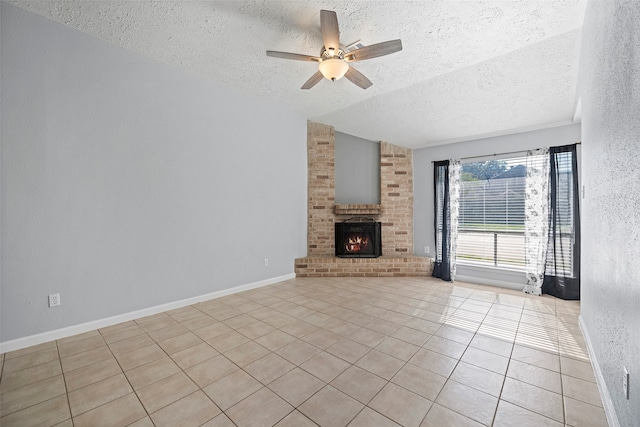 unfurnished living room with a textured ceiling, vaulted ceiling, ceiling fan, a fireplace, and light tile patterned flooring