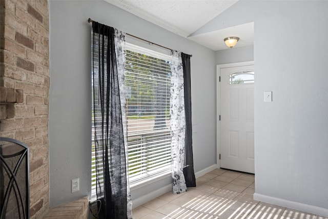 tiled foyer featuring vaulted ceiling