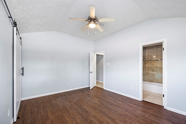 unfurnished bedroom with ensuite bath, ceiling fan, dark hardwood / wood-style flooring, and a textured ceiling