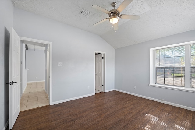 unfurnished bedroom featuring hardwood / wood-style floors, vaulted ceiling, ceiling fan, a textured ceiling, and a closet