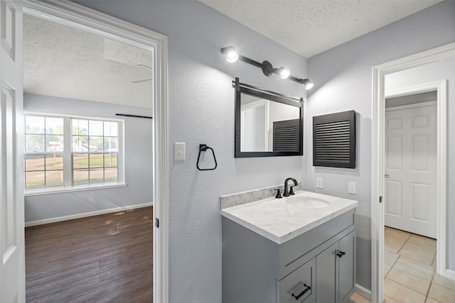 bathroom featuring vanity, wood-type flooring, and a textured ceiling