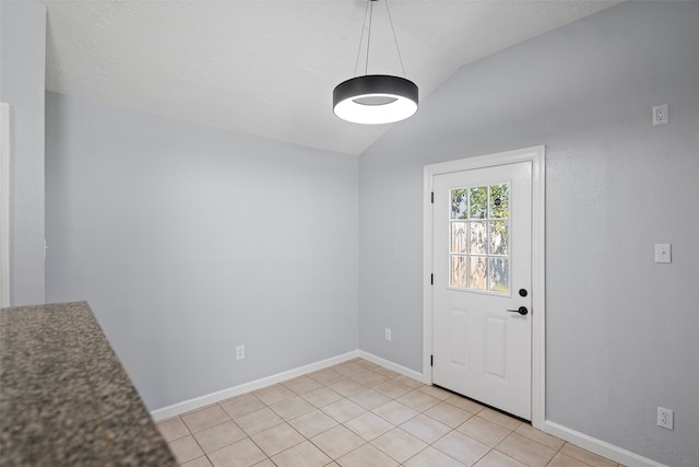 doorway to outside featuring light tile patterned floors and vaulted ceiling