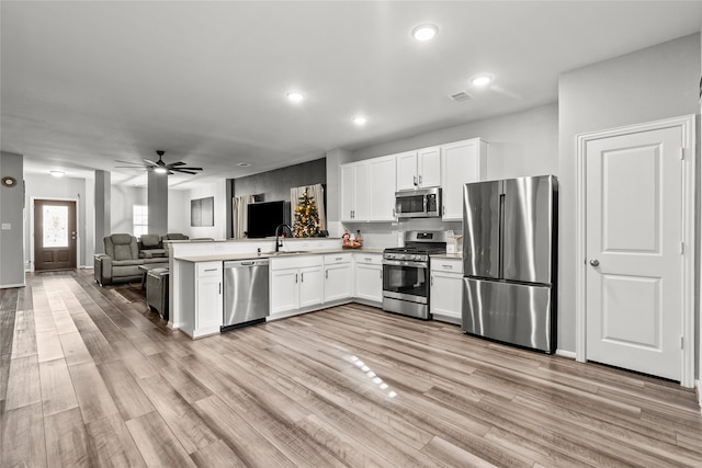 kitchen featuring white cabinets, sink, kitchen peninsula, and stainless steel appliances