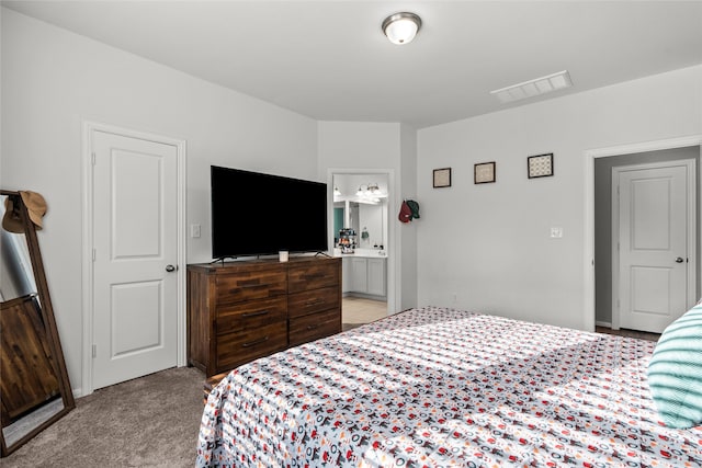 bedroom featuring ensuite bath and light carpet