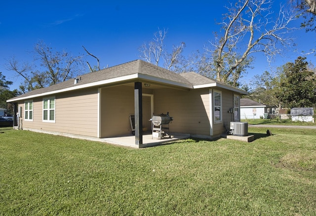 rear view of property featuring a lawn, cooling unit, and a patio