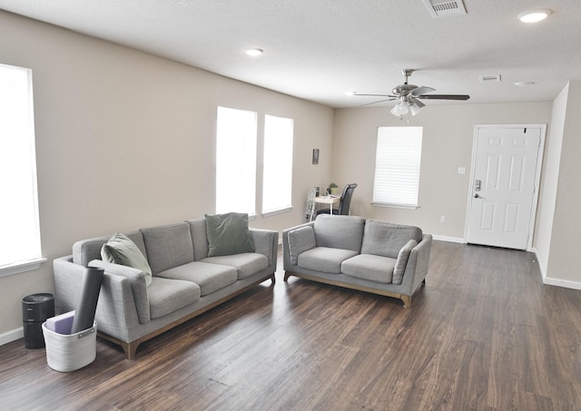 living room with dark hardwood / wood-style floors, ceiling fan, and a textured ceiling