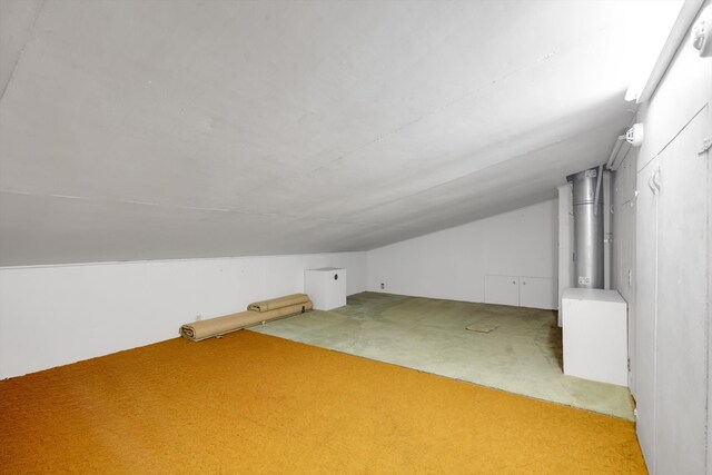 bonus room with carpet and vaulted ceiling