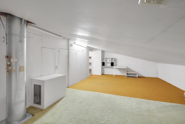 additional living space featuring light colored carpet and vaulted ceiling