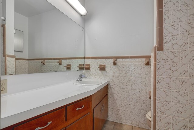 bathroom with tile patterned flooring, vanity, and tile walls