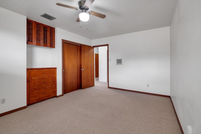 unfurnished bedroom with a closet, light colored carpet, and ceiling fan