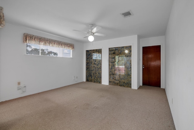 carpeted spare room featuring ceiling fan