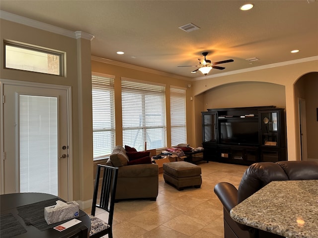 living room featuring a textured ceiling, ceiling fan, and crown molding