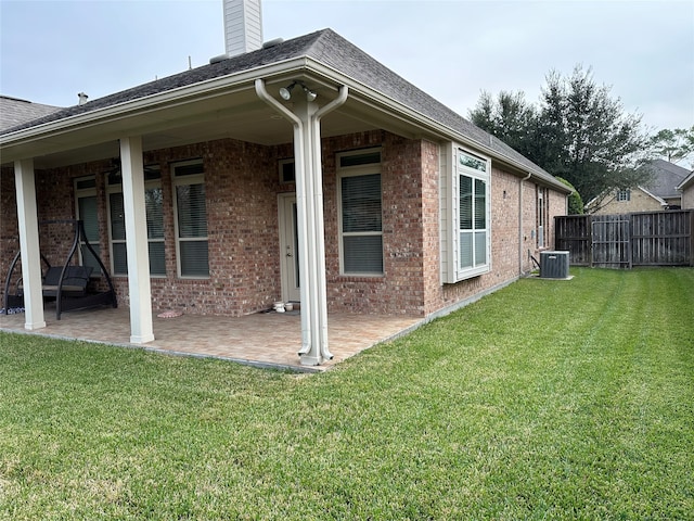 back of property with a patio, cooling unit, and a lawn