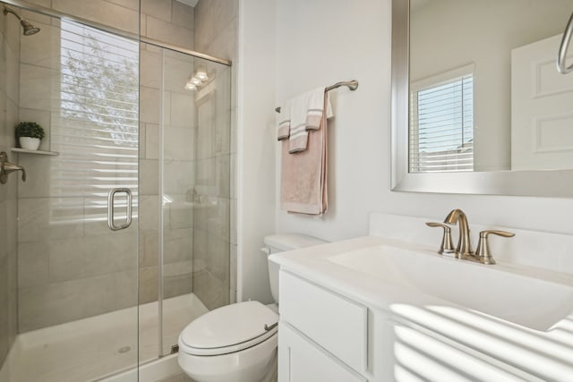 bathroom with vanity, toilet, and a shower with door