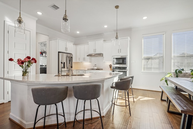 kitchen with white cabinets, pendant lighting, a spacious island, and appliances with stainless steel finishes