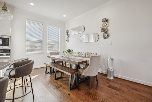 dining space featuring ornamental molding and hardwood / wood-style flooring